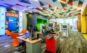 Interior of the West Las Vegas Library. Showing the 3D printing station with reels and 4 printer stations. There is a colorful ceiling of orange and aqua tiles.