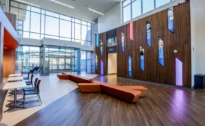 The grand entrance of the library. Wood and tile flooring with wood wall and photos showing image of elected officials.